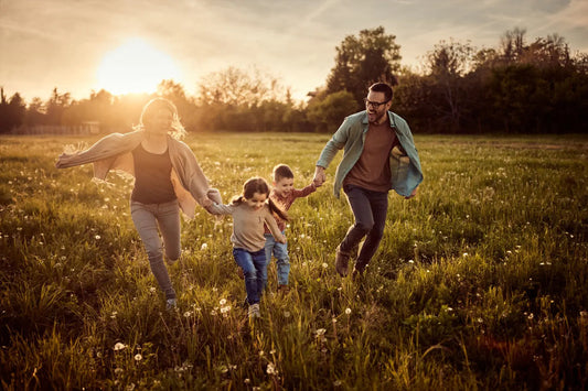 Happy family running in a sunny field at sunset – blog cover for creative summer photoshoot backdrop ideas
