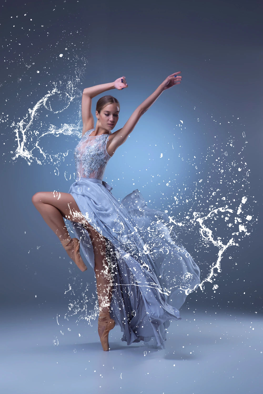 Dancer in a flowing blue dress with water effects on a dark background